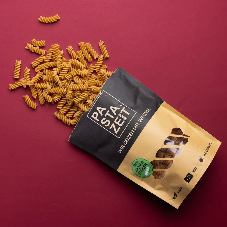 Bio Kichererbsen Fusilli aus der Pastazeit-Packung auf rotem Hintergrund