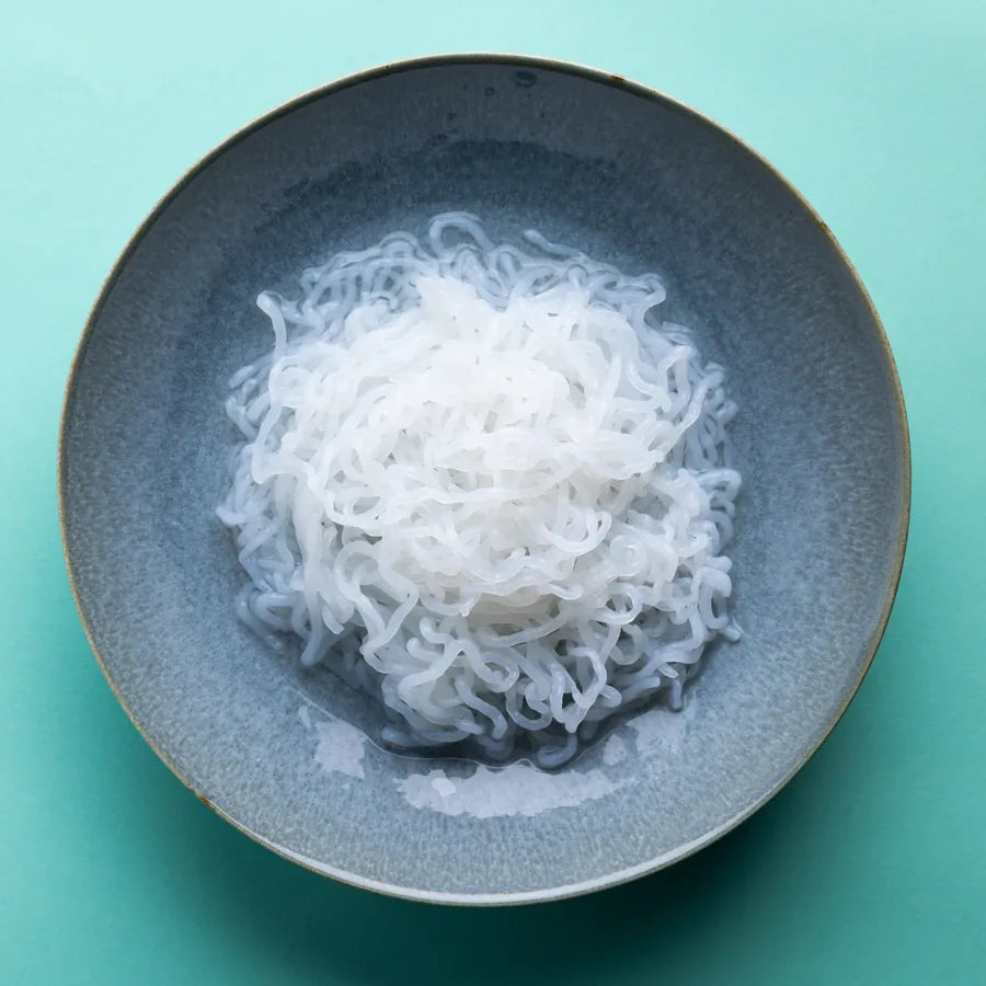 Schale mit Bio Konjak Spaghetti auf türkisem Hintergrund